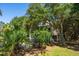 Exterior view of home with mature trees and landscaping, offering a glimpse of the tranquil setting at 8869 Marsh Aire Ln, Edisto Island, SC 29438