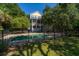 Backyard fenced pool with clear water and a multi-story home nestled amongst the trees at 8869 Marsh Aire Ln, Edisto Island, SC 29438