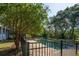 Backyard pool is surrounded by a black iron fence and mature trees, providing seclusion at 8869 Marsh Aire Ln, Edisto Island, SC 29438