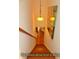 A wooden staircase with custom lighting fixture and art at 8869 Marsh Aire Ln, Edisto Island, SC 29438