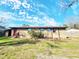 Back exterior elevation with brick walls, a shed, green grass, and blue skies with light, puffy clouds at 9 Grover Ln, Goose Creek, SC 29445