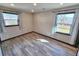 Bright bedroom featuring two windows with curtains and wood-look flooring at 9 Grover Ln, Goose Creek, SC 29445