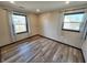 Corner bedroom featuring two windows with curtains and wood-look flooring at 9 Grover Ln, Goose Creek, SC 29445