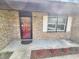 Close up of the front porch with a decorative red door, brick facade, and a small garden at 9 Grover Ln, Goose Creek, SC 29445