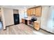 Modern kitchen featuring stainless steel appliances, wood cabinets, stone countertops, and wood-look vinyl flooring at 9 Grover Ln, Goose Creek, SC 29445