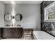 Bright bathroom featuring double sinks, dark wood cabinets, and a soaking tub with stylish fixtures at 915 Dill Ave, Charleston, SC 29412