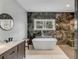 Modern bathroom featuring a soaking tub, dark marble accent wall, and elegant fixtures at 915 Dill Ave, Charleston, SC 29412
