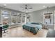 Sunlit bedroom with a ceiling fan, light walls, beautiful wooden floors, and a comfortable bed with blue comforter at 915 Dill Ave, Charleston, SC 29412