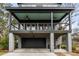 Front of the property featuring a covered porch, modern railing, and a visible two-car garage at 915 Dill Ave, Charleston, SC 29412