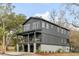 Striking two-story home with gray siding, modern windows, and a covered porch, surrounded by lush trees at 915 Dill Ave, Charleston, SC 29412