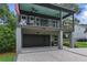 A garage with a dark door is located beneath a lovely porch with two ceiling fans at 915 Dill Ave, Charleston, SC 29412