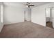 Large carpeted bedroom featuring a ceiling fan, connecting doors, and natural light at 9747 Roseberry Street, Ladson, SC 29456