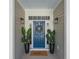 Welcoming blue front door adorned with a wreath, flanked by potted plants and modern sconces at 1013 Barfield St, Charleston, SC 29492