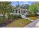 Charming home with a welcoming front porch, American flag, blue shutters, and mature landscaping at 1013 Barfield St, Charleston, SC 29492