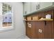 Well-organized laundry room with stylish wood slat wall, green cabinets, and a view to the outside at 1013 Barfield St, Charleston, SC 29492