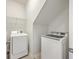 Well-lit laundry area with modern washer, dryer, and convenient overhead shelving for ample storage solutions at 106 Kirkland St, Goose Creek, SC 29445