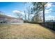 This fenced, grass backyard with pool is bordered by mature trees providing outdoor privacy and space for recreation at 106 Rachel St, Goose Creek, SC 29445