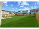 Expansive fenced backyard with lush green grass and patio seating area at 1105 Mossy Rock Dr, Summerville, SC 29485