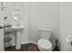 Neat powder room with pedestal sink, modern toilet, and dark wood-look flooring at 1105 Mossy Rock Dr, Summerville, SC 29485