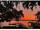 Picturesque sunset view from the yard showing a private dock and boat with vibrant skies at 119 Riverland Dr, Charleston, SC 29412