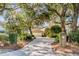 Brick home with large front yard framed by moss-draped trees and verdant landscaping at 119 Riverland Dr, Charleston, SC 29412