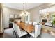 Bright dining room with dark wood table, seating for ten, stylish chandelier, and hardwood floors at 121 Jakes Ln, Mount Pleasant, SC 29464