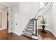Bright foyer with curved staircase featuring white railings, gray carpet, and dark wood floors at 121 Jakes Ln, Mount Pleasant, SC 29464