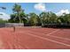 A view of the Ion Club tennis court with well maintained red surface and new net at 121 Jakes Ln, Mount Pleasant, SC 29464