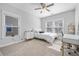 Bright bedroom features a ceiling fan, large windows, and a comfortable bed with a modern desk at 121 Warbler Way, Summerville, SC 29483