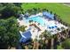 Aerial view of a vibrant community pool area with multiple pools, lounge chairs, and lush landscaping at 121 Warbler Way, Summerville, SC 29483