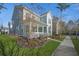 Attractive two-story home featuring a cozy front porch, well-kept lawn, and lovely landscaping at 121 Warbler Way, Summerville, SC 29483