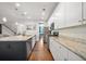 Open kitchen with a large island, granite countertops, and white cabinets, flowing seamlessly into the living area at 121 Warbler Way, Summerville, SC 29483