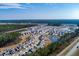 Aerial view of a neighborhood with homes surrounding a lake and green space at 127 Surfbird Rd, Summerville, SC 29486