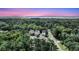 Stunning aerial view of three modern homes nestled amongst lush greenery with scenic waterfront views at sunset at 1308 Lieben Rd, Mount Pleasant, SC 29466