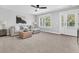 Bright living room with a gray sectional sofa, woven ottoman, ceiling fan, and a door to the outside at 1308 Lieben Rd, Mount Pleasant, SC 29466