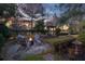 Cozy backyard fire pit area surrounded by mature trees, a garden, and well-manicured landscaping at 15 Watroo Pt, Daniel Island, SC 29492