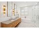 Luxurious bathroom with a double vanity, marble countertops, a soaking tub, and a glass-enclosed shower at 15 Watroo Pt, Daniel Island, SC 29492