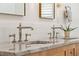Close-up of a bathroom vanity with double sinks, elegant fixtures, marble countertop, and decorative accents at 15 Watroo Pt, Daniel Island, SC 29492