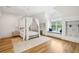 Bright bedroom with a canopy bed, a window seat, built-in shelves, and hardwood floors, offering a cozy retreat at 15 Watroo Pt, Daniel Island, SC 29492