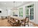 Bright dining room with a rustic wooden table, bench, and chairs, featuring french doors and a modern light fixture at 15 Watroo Pt, Daniel Island, SC 29492