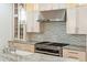 Close up of gourmet kitchen details, including custom cabinets, a gas range, and marble countertops at 15 Watroo Pt, Daniel Island, SC 29492
