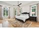 Elegant main bedroom with a large bed, stylish rug, and abundant natural light from large windows at 15 Watroo Pt, Daniel Island, SC 29492