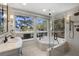 Bright bathroom featuring a soaking tub, walk-in shower, and scenic outdoor views at 161 Marsh Hawk Ln, Kiawah Island, SC 29455