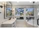 Bright bathroom featuring a soaking tub, walk-in shower, and scenic outdoor views at 161 Marsh Hawk Ln, Kiawah Island, SC 29455