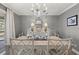 The dining room features a chandelier, gray wallpaper, and a dining room set at 161 Marsh Hawk Ln, Kiawah Island, SC 29455