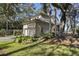 Beautiful home featuring an attached garage, a manicured lawn, and mature trees at 161 Marsh Hawk Ln, Kiawah Island, SC 29455