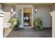 Inviting entryway with decorative potted plants, transom windows, and outdoor lighting at 161 Marsh Hawk Ln, Kiawah Island, SC 29455