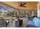Cozy screened porch with ample seating, a ceiling fan, and serene views of the surrounding landscape at 161 Marsh Hawk Ln, Kiawah Island, SC 29455