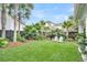 Lush backyard with manicured lawn, bordered by tropical plants and mature trees at 164 River Green Pl, Charleston, SC 29492