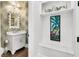 Elegant powder room featuring a stylish vanity, decorative mirror, and vibrant tropical-themed wallpaper at 164 River Green Pl, Charleston, SC 29492